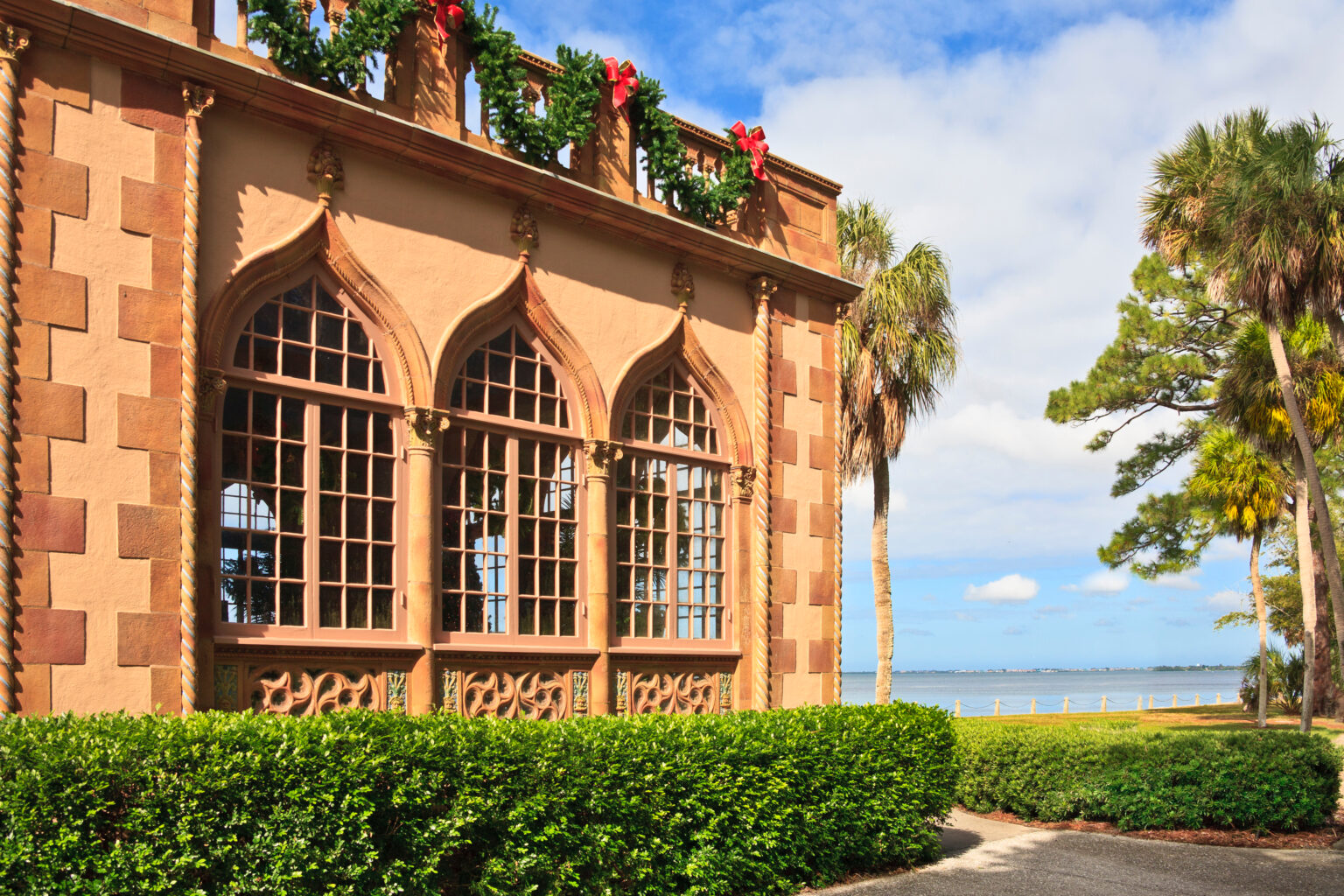 Ringling Mansion at Christmas A building with a large window and a garden.