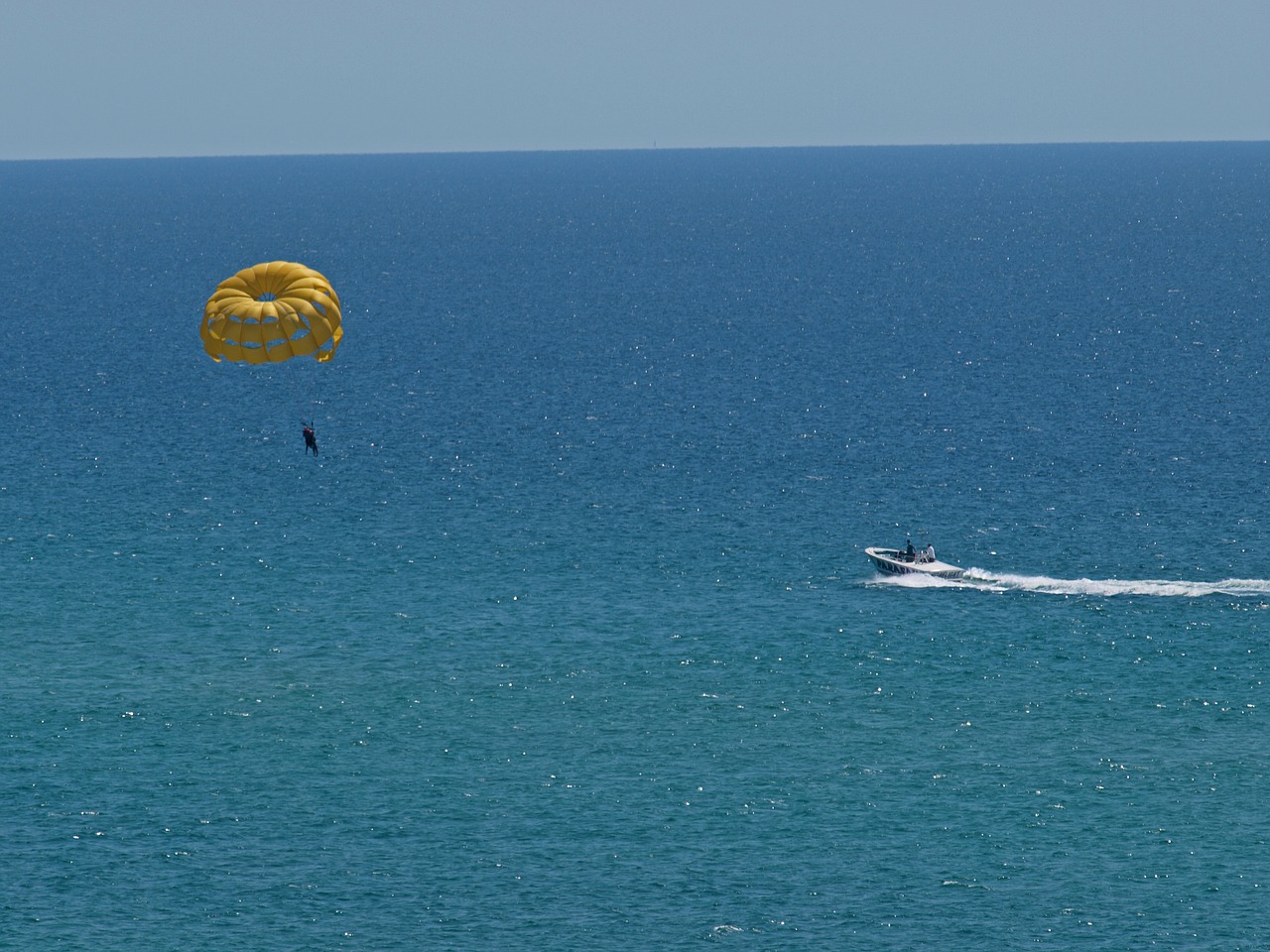 A person parasailing in the ocean with a parachute.