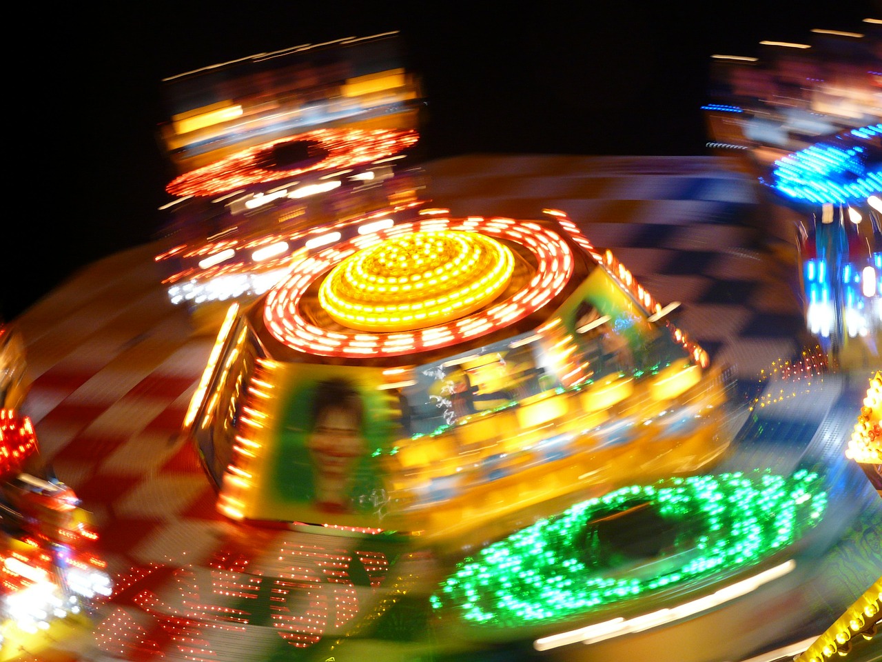 A blurry picture of a carnival ride at night.