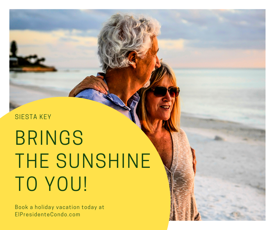 A couple of people standing on top of a beach.