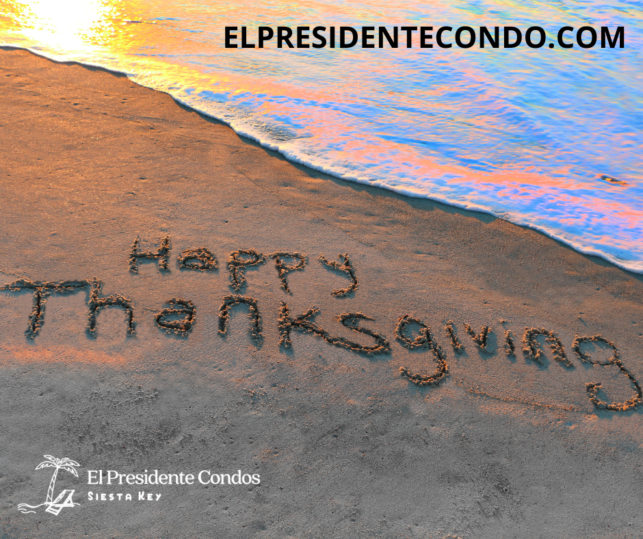 A beach with the words happy thanksgiving written in sand.
